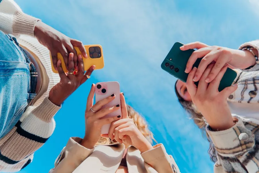 Three girls on their phones.